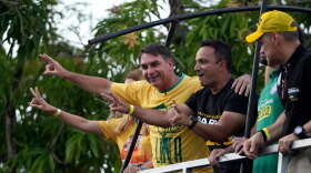 Opposition presidential candidate Sen. Flavio Bolsonaro, left, gestures to supporters from a vehicle during a campaign motorcade in Belem, Para state, Brazil, Monday, Sept. 14, 2026.