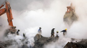FILE - In this Oct. 11, 2001 file photo, firefighters make their way over the ruins of the World Trade Center through clouds of dust and smoke at ground zero in New York. With the Oct. 3, 2013 deadline looming, more than 32,000 people have applied to the federal compensation fund for people with illnesses that might be related to toxic fallout from the attacks, program officials said. (AP Photo/Stan Honda, Pool, File)