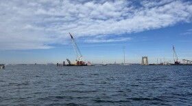 A crane helps put in test piles into the Patapsco River bed on November 5, 2025. The piles will hold up to 10 million pounds to ensure the soil is safe for the new Key Bridge.