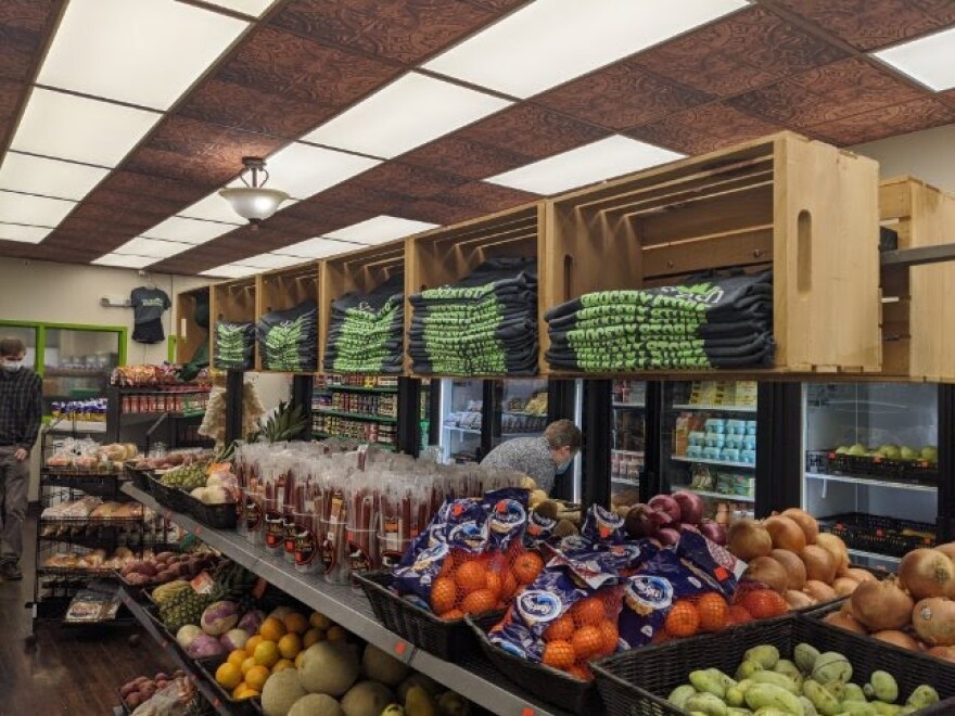 Fruits, vegetables and other items are piled inside a store.