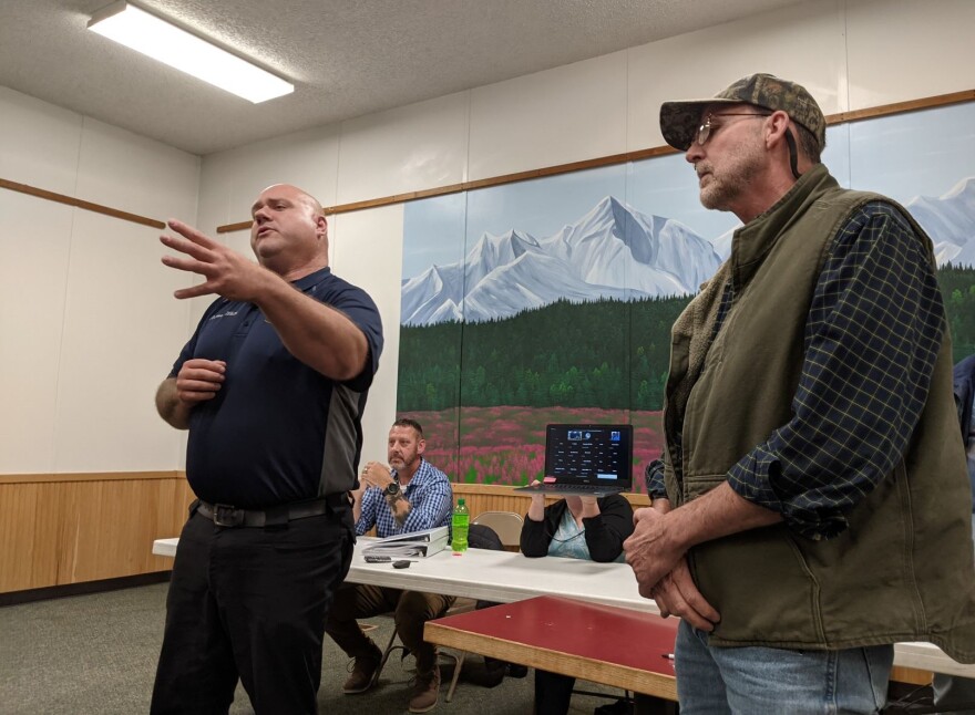 Delta Medical Transport co-owner Tony White, left, explains funding issues as James Squyres, an area resident who's skeptical of proposals to levy a tax to supplement ambulance service, waits to respond. Seated at the table are City Administrator Ken Greenleaf, left, and Flower Cole, administrative assistant, partially obscured by a laptop she's holding.