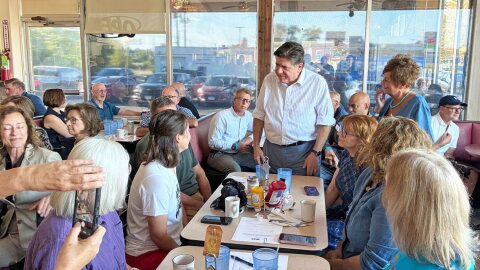 Gov. JB Pritzker speaks to Emily Waugh of Oregon at Lulu’s Diner in Springfield on Thursday, Aug. 27, 2026.