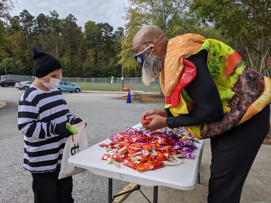 Lakewood Elementary Principal James Hopkins offers candy to student Gabriel Burch on Oct. 31, 2020.