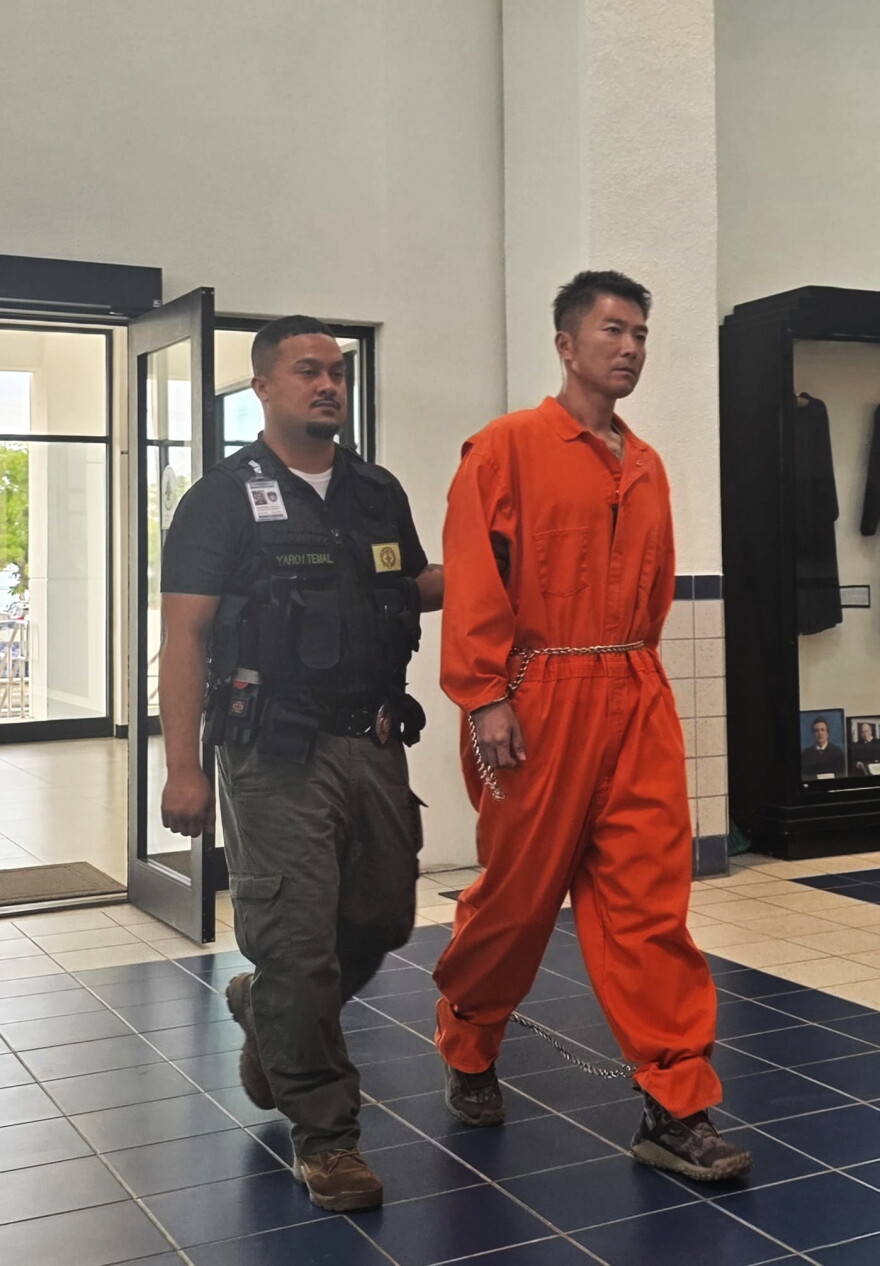 Longgui “Andy” Yan, 39, arrives in CNMI Superior Court Wednesday for a bail hearing escorted by Corrections officers.