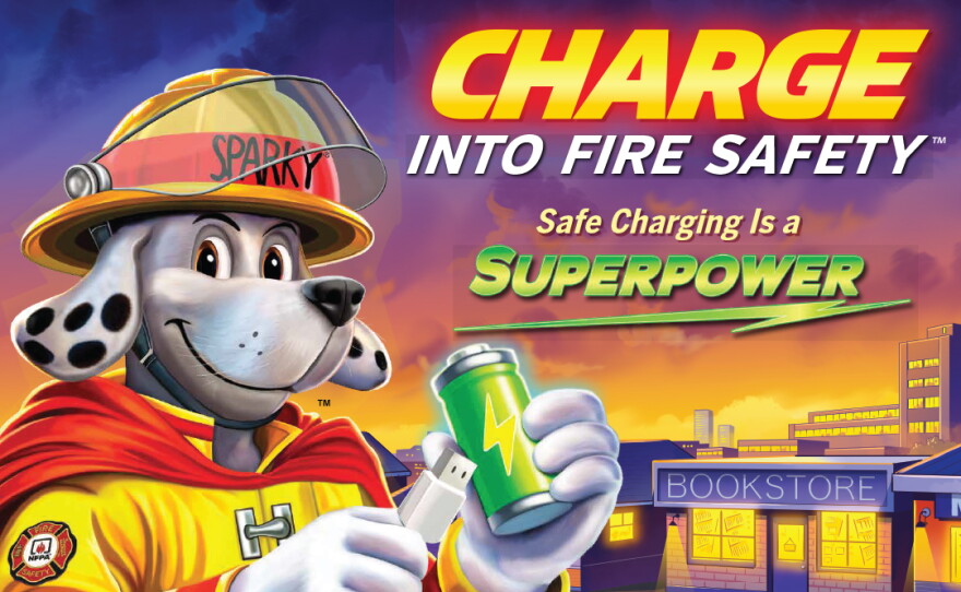 Cartoon image of Sparky, the National Fire Prevention Association's mascot, holding a cell phone charger and a battery - a campaign image for "Charge into Fire Safety - Safe Charging is a Superpower."