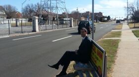 Person on bench at bus stop