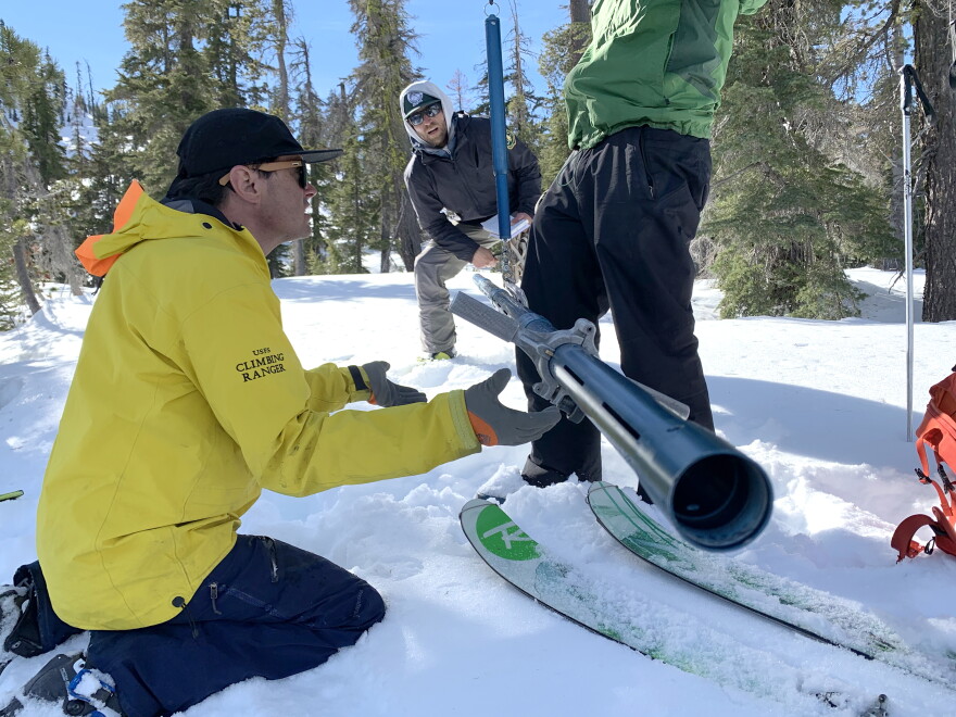 Mt. Shasta Avalanche Center forecasters Aaron Beverly and Ryan Lazzeri and National Weather Service forecaster Brett Lutz weigh snow samples in the Shasta-Trinity National Forest.
