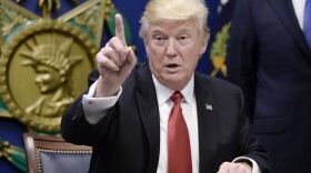 President Donald Trump signs executive orders in the Hall of Heroes at the Department of Defense on Friday in Arlington, Va.
