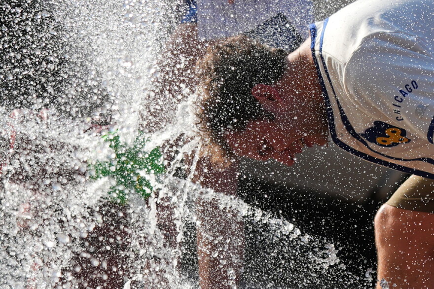  A person cools off with his head in a water spray 