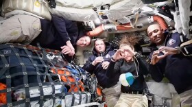 This image from video provided by NASA shows the Artemis II crew Commander Reid Wiseman, second from left, thanking the families of the crew while speaking with NASA Mission Control in a video conference while en route to the moon, Thursday, April 2, 2026, as Canadian astronaut and mission specialist Jeremy Hansen, far left, looks on and mission specialist Christina Koch and pilot Victor Glover, far right, make hearts with their hands. (NASA via AP) CORRECTION: headed to the moon, not in moon's orbit