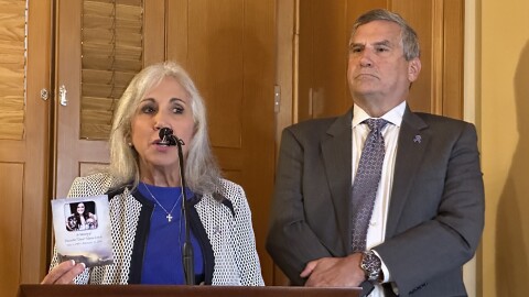 Donna and Jeff Heck at a suicide prevention press conference, with a photo of their daughter, in September 2024.