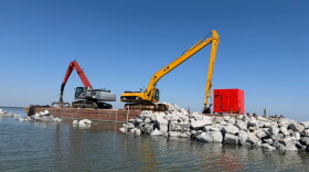 Engineers install rock breakwaters along the shoreline of Coffee Island.