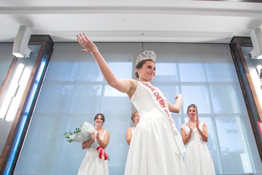Magdalen Kleinrichert reacts after being crowned the 2026-27 National Cherry Queen by outgoing queen Ainslee Hewitt during Friday’s National Cherry Festival Queen’s Coronation at the Park Place Hotel in Traverse City.