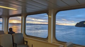 A passenger looks out the window of a Washington State Ferry the morning of Dec. 31, 2023 en route from Friday Harbor, San Juan Island, to Anacortes. Photo by Annie Warren / NWPB