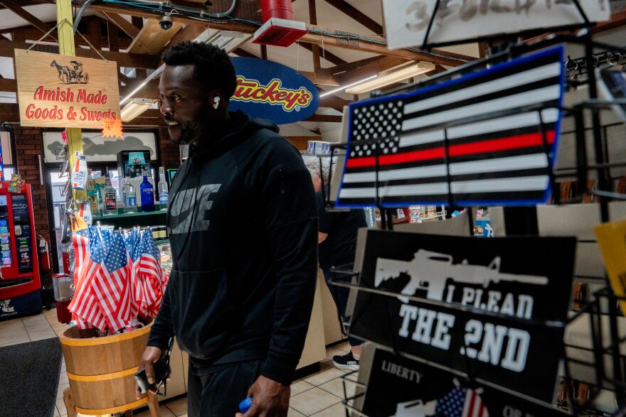 Trey Parson, 33, of Oklahoma City, Ok., walks by an assortment of bumper stickers at Stuckey’s on Monday, June 16, 2025, near Doolittle, Mo. Parson said he was in town visiting his girlfriend who is a travel nurse at one of the local hospitals.