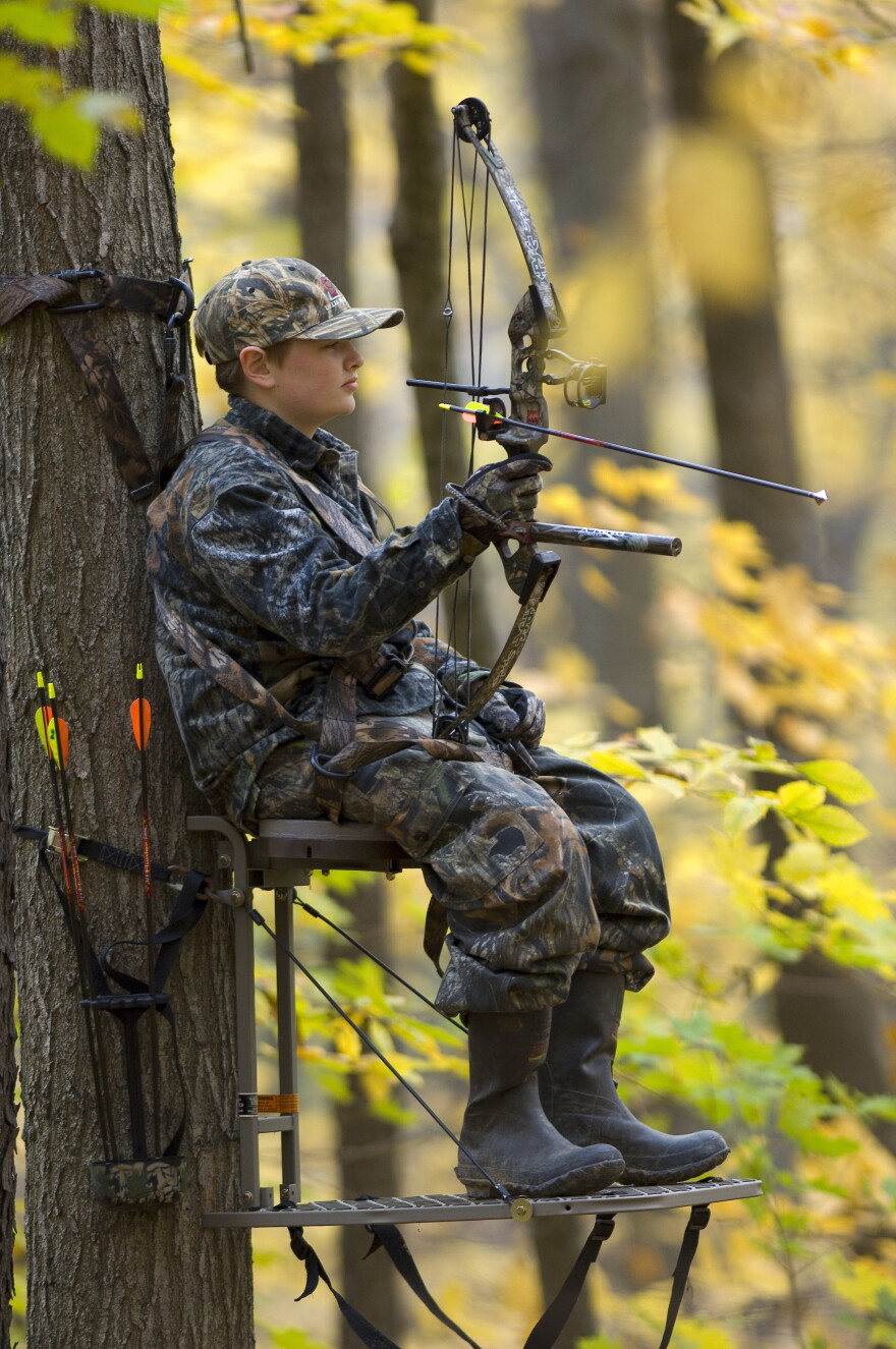 Youth deer hunting with a bow from a tree stand.