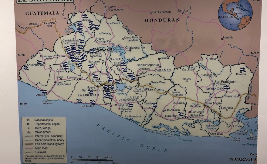 Visitors place flags on a large wall map inside the consulate, showing towns and cities of origin.