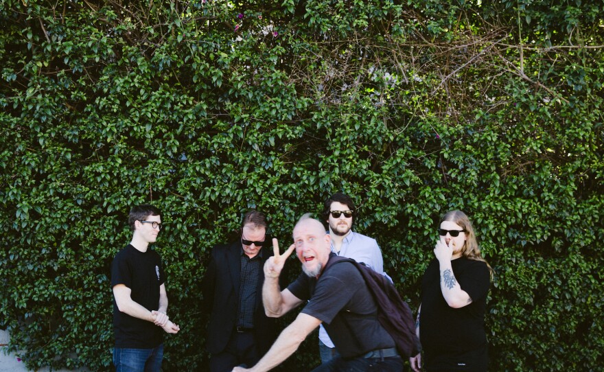 A random cyclist passes in front of the band during a photo shoot in Los Angeles. (According to the band's publicist, that cyclist turned out to be Hunter Jackson, aka Techno Destructo of the band Gwar).