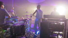 Band playing on stage in a purple haze