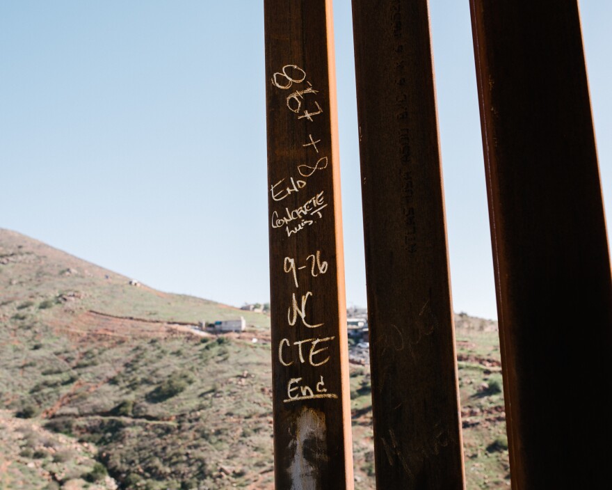 Construction notations written on the last steel slat in a section of the border fence.