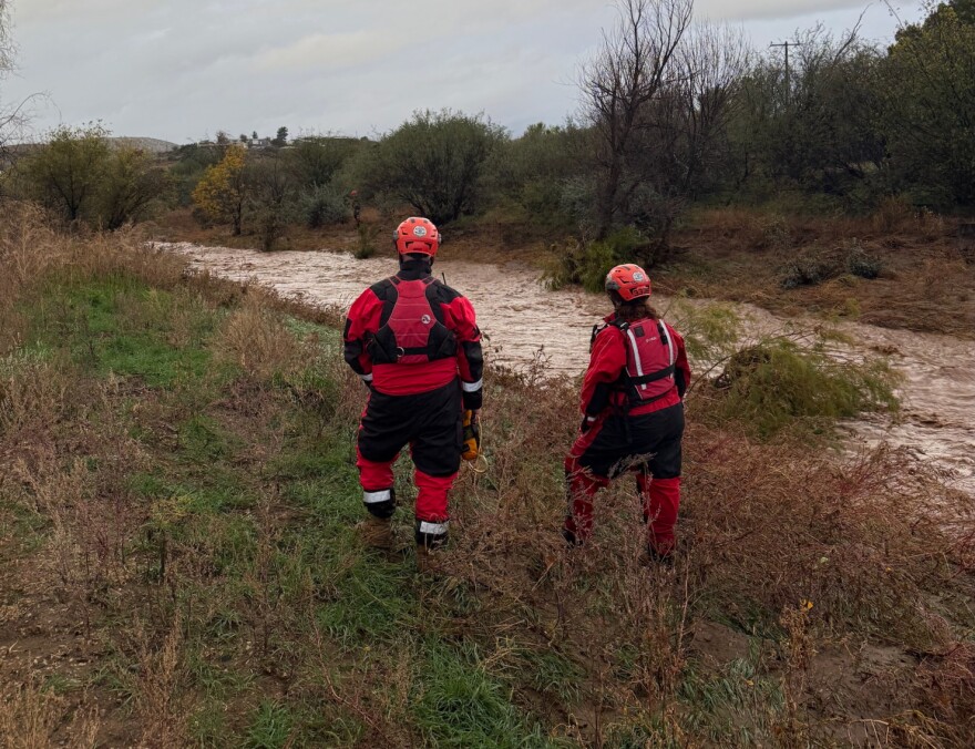 Two first responders stand next to Big Bug Creek in the Cordes Lakes community on Tue, Nov. 18, 2025. It was the site of a flash flood that carried off a car and an elderly man who was driving after 2–3 inches of rain fell over the area during the course of two days.
