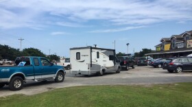Vehicles line up at the a gas station on Thursday, July 27, 2017, on Ocracoke Island on North Carolina's Outer Banks, as visitors leave the island and residents fuel up. An estimated 10,000 tourists were ordered Thursday to evacuate the island after a construction company caused a power outage, leaving people stranded without air conditioning or places to eat. (C. Leinbach/Ocracoke Observer via AP)