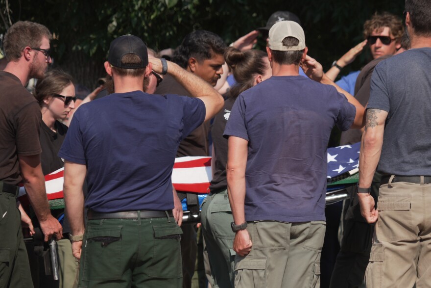 The body of a firefighter who died battling wildfires near the Colorado-Utah border is carried during a procession in Grand Junction, Colo., Monday, June 29, 2026.