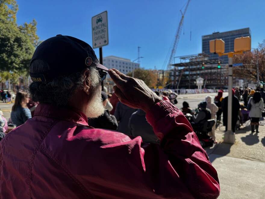 Dwight Tillman salutes as the "Star-Spangled Banner" is sung in the distance. Tillman was unable to speak because of a recent illness, but he came out to "show support to everyone."