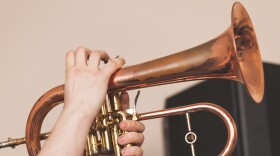 Live music background, flugel horn in trumpeter hands, close-up photo with selective focus