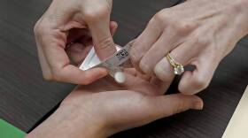 A patient prepares to take the first of two combination pills, mifepristone, for a medication abortion. (Charlie Riedel/AP)
