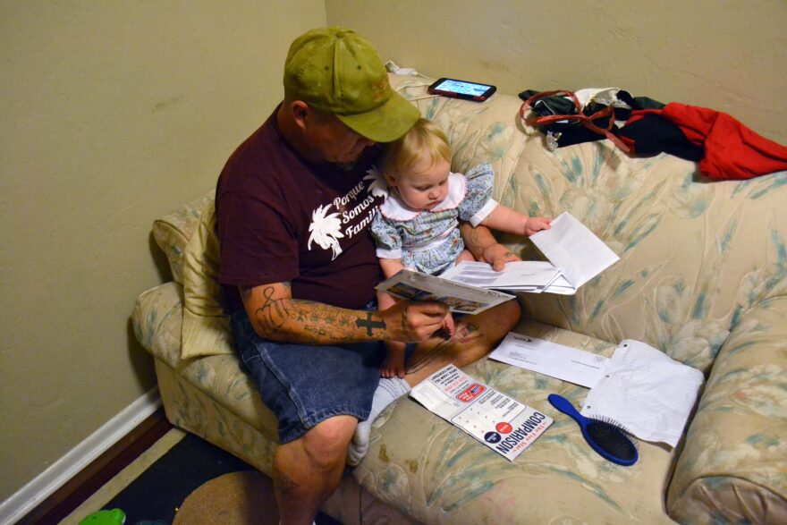 Sandy opens a stack of mail. Bills, advertisements and junk mail pile up. (Monica Humphries/WUFT News) 