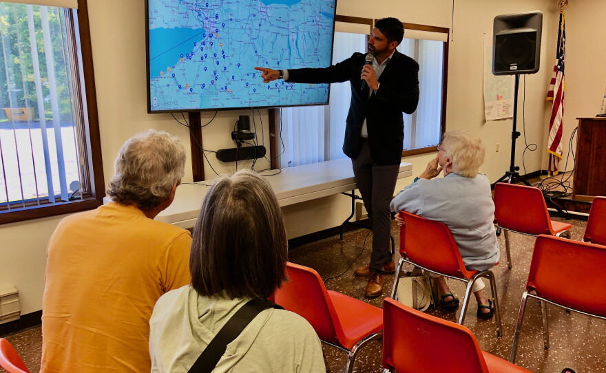 NY23 Democratic Party and Working Families Party candidate Aaron Gies shows Campbell town hall attendees upcoming events on a map of the district.