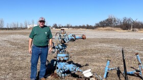 Jeff McCaskill, director of the University of Oklahoma's Tuttle geothermal project, stands next to a retired well the team is converting for geothermal use.