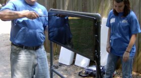 IBM employee James Schweitzer and volunteer Ruby Gilliland assembling a portable solar panel to power a new web cam at the