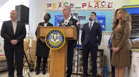 Six months after the creation of the CT Baby Bonds program, Governor Ned Lamont (at podium) reported January 17, 2024, that 7,810 Connecticut children born after July 01, 2023, have been enrolled in the program. Baby Bonds, under the direction of State Treasurer Erick Russell (second from right), invests $3,200 on behalf of each low-income child.