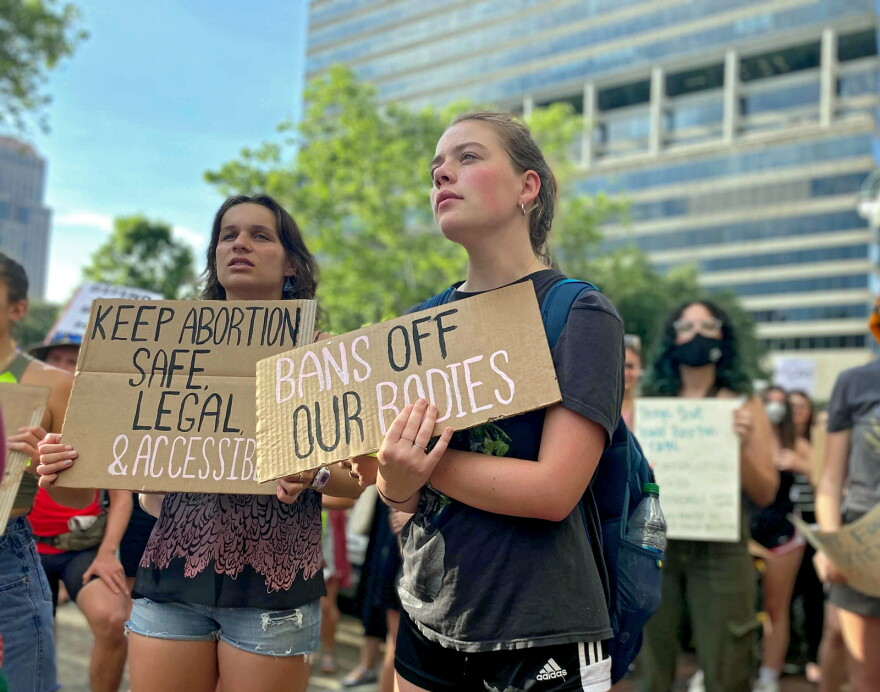 Two unidentified women hold up signs supporting abortion rights at a rally held outside of the U.S. 5th Circuit Court of Appeals courthouse in downtown New Orleans, May 3, 2022. The rally was held in response to a report from Politico that leaked an initial draft of a Supreme Court majority opinion striking down Roe v. Wade.