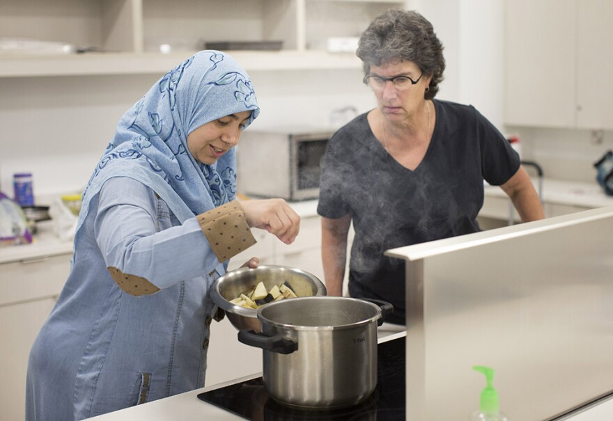 Shereen Abdelfattah, left, adds eggplant to boiling oil as Melissa Michos watches during a Mediterranean and Middle Eastern cooking demonstration at the Forsyth County Library, on Saturday, July 21, 2018, in Winston-Salem, N.C. 