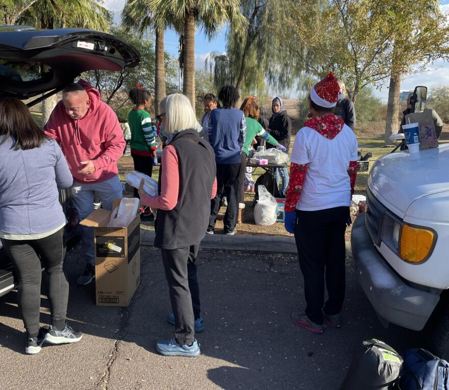 People get items out of the back of a vehicle