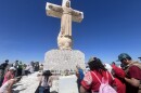 People pray at the foot of the white sculpture of Jesus Christ after making a Good Friday pilgrimage to the top of Mount Cristo Rey in Sunland Park, New Mexico.