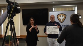 Peoria County Board chairman Andrew Rand, center, used a series of placards to help communicate about COVID-19 during a press conference Friday, April 3, 2020 at the Peoria City/County Health Department.