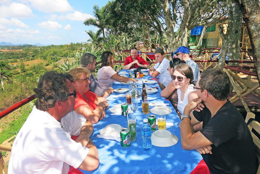 Several people at outdoor table eating a meal in Cuba.  
