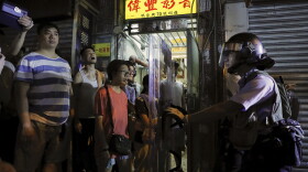 Residents watch policemen arresting people on a street during a face off at Sham Shui Po district in Hong Kong, Wednesday, Aug. 7, 2019. (Kin Cheung/AP)