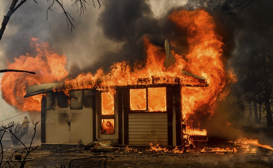 Flames from the Morton Fire consume a home near Bundanoon, New South Wales, Australia, on Thursday.