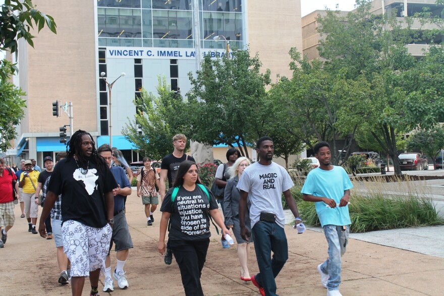 Bruce Franks, center, walks with supporters to the St. Louis  courthouse to file an official challenge to his state House primary contest on August 17.