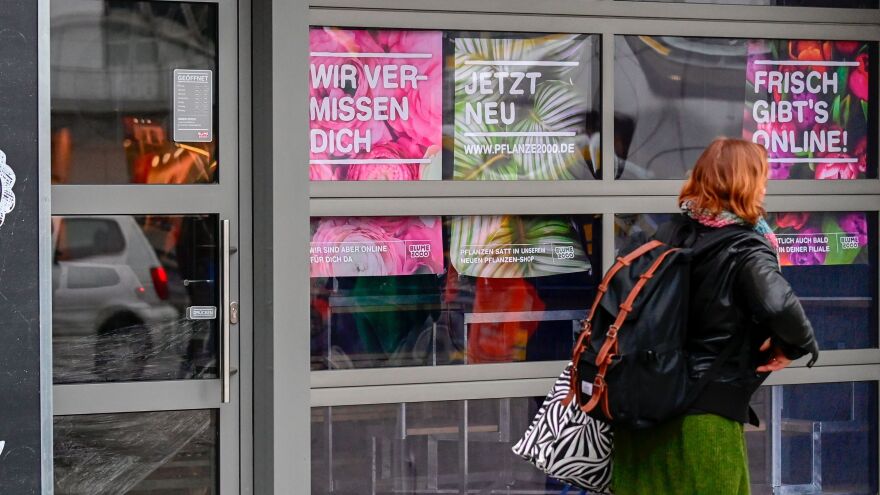 A woman walks past a closed flower shop in Berlin on Thursday. A research group noted more than 1,200 new words in German inspired by the pandemic.