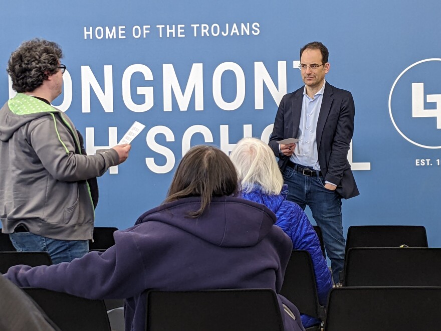  Colorado Attorney General Phil Weiser listens to Trevor McCarthy, a Safeway employee in Longmont, who is concerned about the possible merger of Kroger and Albertsons. McCarthy was one of about 25 people who attended a community meeting at Longmont High on Tuesday, April 25.