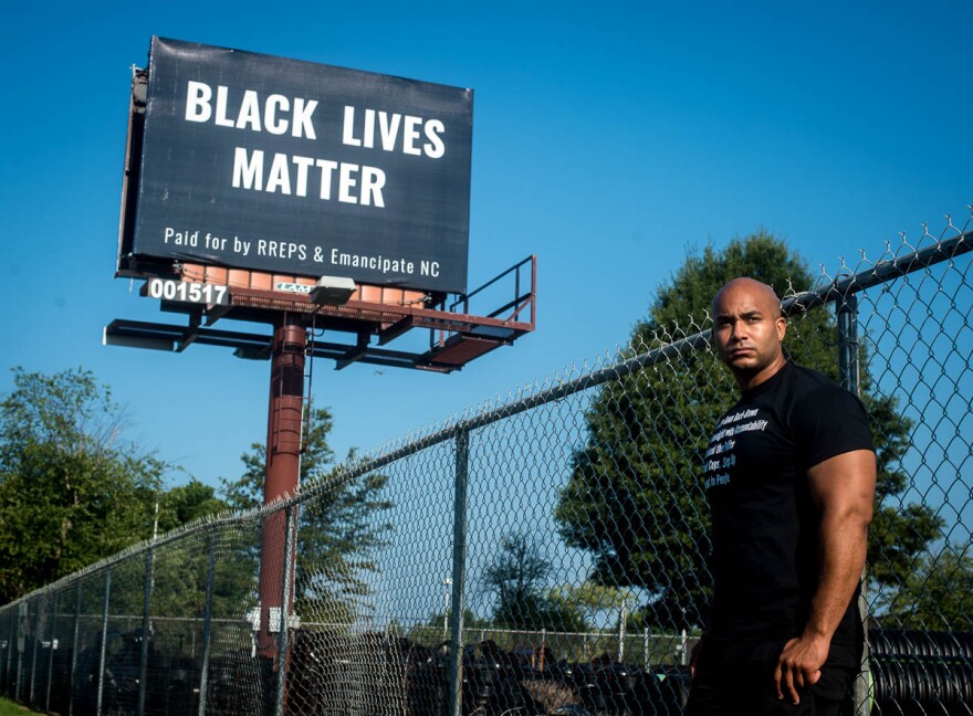 Kerwin Pittman, 33, stands in front of a Black Lives Matter billboard that he has placed on Tryon Road in Raleigh's Southside for one month. This is the second Black Lives Matter billboard in a campaign he plans to take statewide.