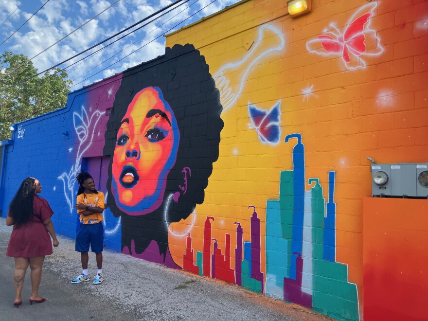 Rock Island artist Zay Williams celebrates the dedication of his new mural on the side of Celebrity's Beauty Supply, 1600 Harrison St., Davenport, on Friday, Sept. 4, 2026.