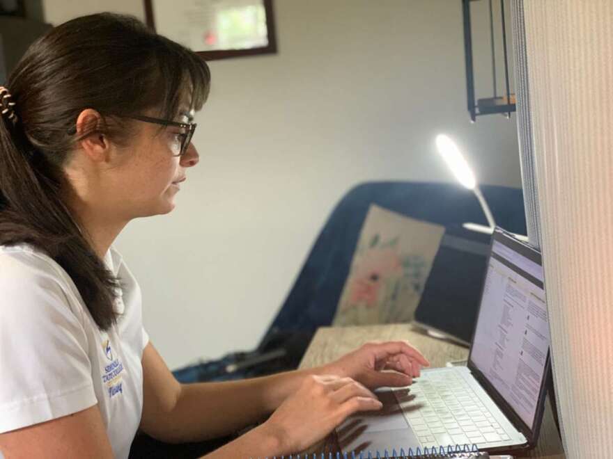 Kamice Klein sits at her computer desk in her East Orlando bedroom preparing for the first day of school. 