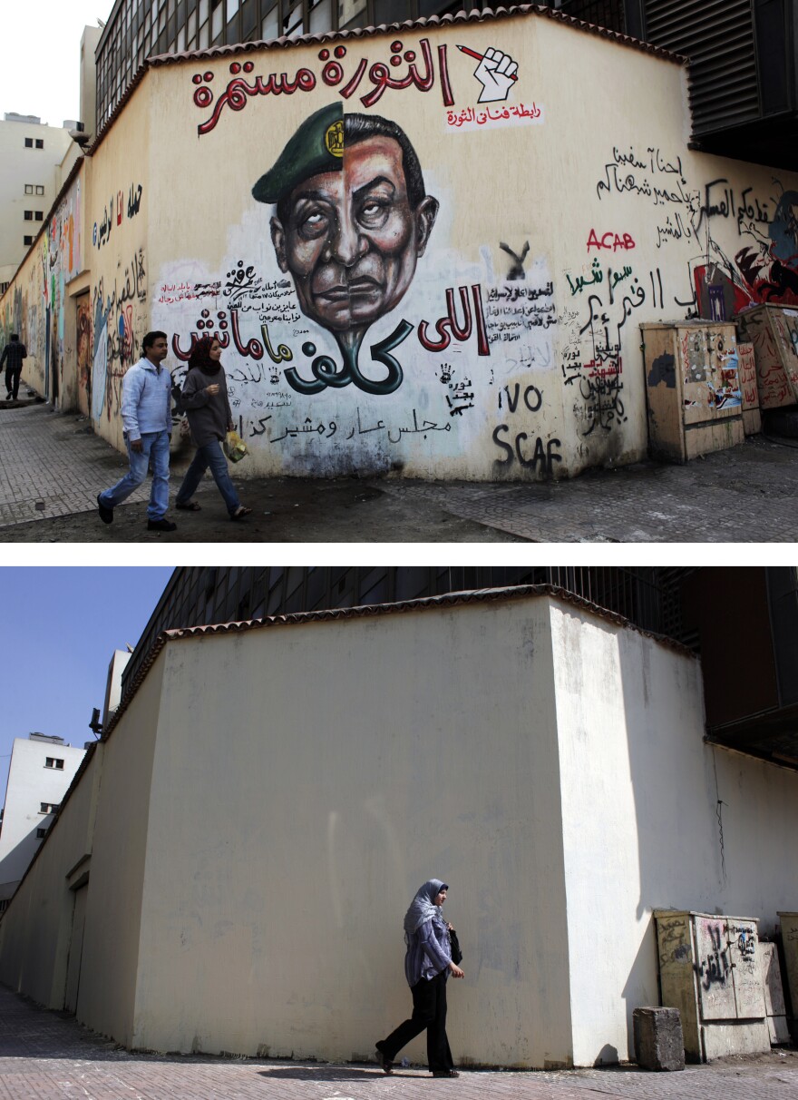 A mural (pictured above in March) was whitewashed (below) during a cleanup campaign in Cairo's Tahrir Square in September. Graffiti artists repainted the wall soon after.